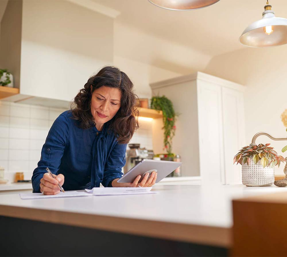 Woman with digital tablet working in modern kitchen